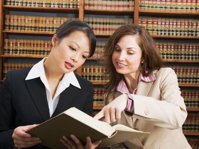 business women looking at library reference book