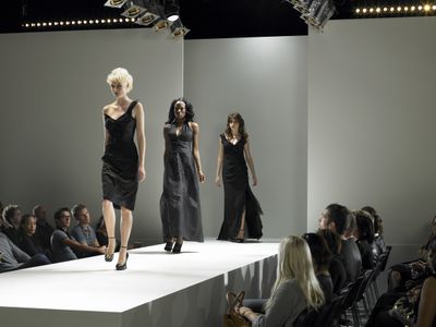 Spectators watching fashion models on catwalk