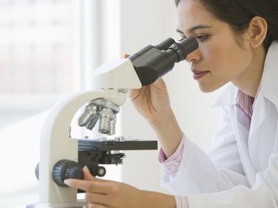 Female doctor using microscope