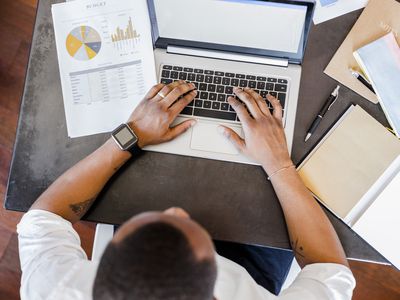 Man using laptop at desk in home office