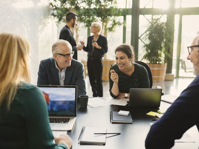 Smiling businesswoman discussing with colleagues in creative office