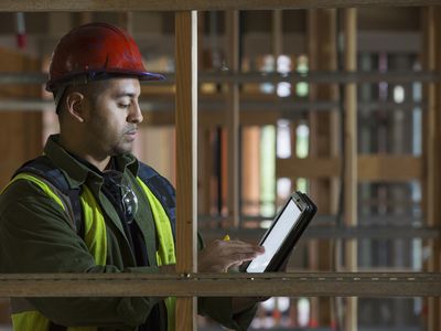 Construction manager reviewing electronic tablet on site