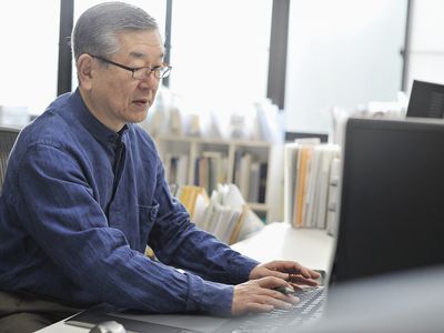 在办公室里的计算机上工作的高级男子
