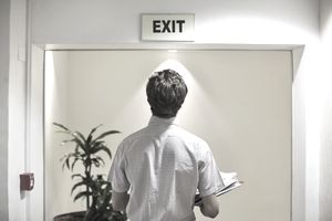 Businessman examining exit sign in office