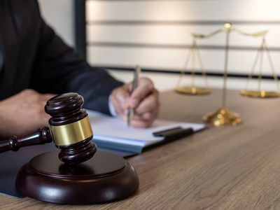 Midsection Of Lawyer Writing On Desk In Office