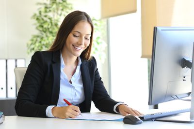 妇女在办公室签署商业信件