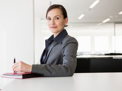 Businesswoman at desk holding pen
