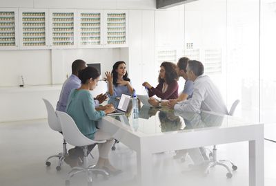 Business people at meeting, by glass table