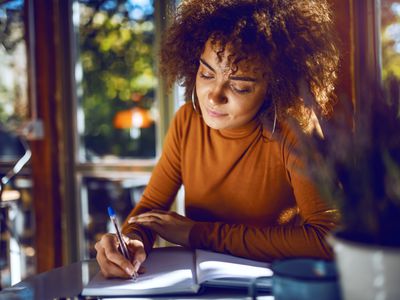 A woman is writing in a journal.