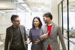 Business people walking and talking in office corridor