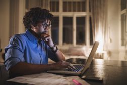 Focused black student working on his laptop computer