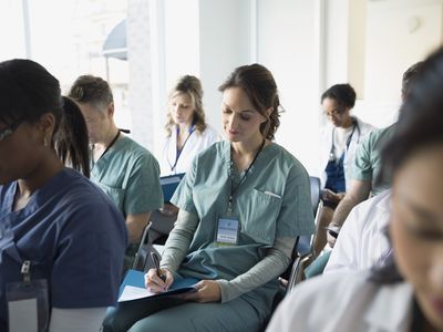 Nurse taking notes in seminar audience