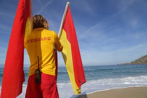 Lifeguard on beach with flags