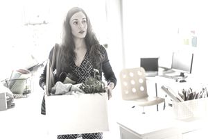 西班牙裔女商人将纸板箱载在办公室