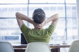 business woman rubbing her neck at her desk, frustrated with her job.