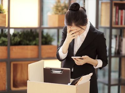 失望的女商人站在办公室里纸板箱