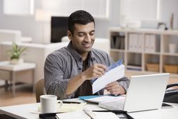 Man opening mail in home office