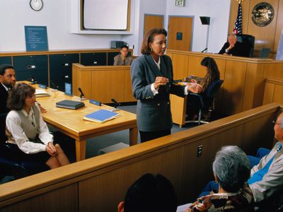 Lawyer speaking to jury in a courtroom setting.