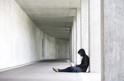 一个男人坐在笔记本电脑上工作的男人的长远景色