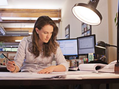 Woman working at her desk, developing a strategy to manage change in a project.