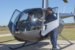 Flight instructor showing student pilots flight deck of helicopter