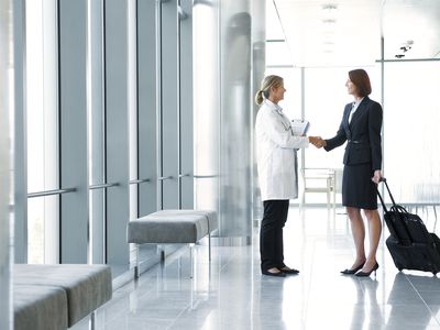Pharmaceutical rep with product samples shaking the hand of a doctor before a sales presentation