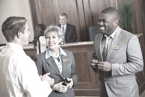 Hotel management discussing something with guest in the lobby