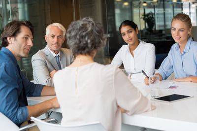 Woman using a well-organized agenda to run a successful meeting in an office.
