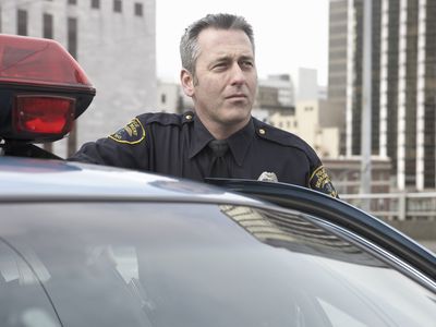 等待巡逻车的年长男警察