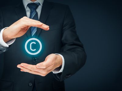 a man's hands cupping a levitating copyright symbol