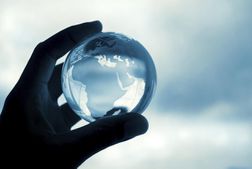 A hand holding a crystal globe