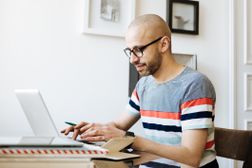 Bald Man Working On Laptop At Home