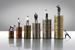 Stack of coins from low to high,tiny men on top