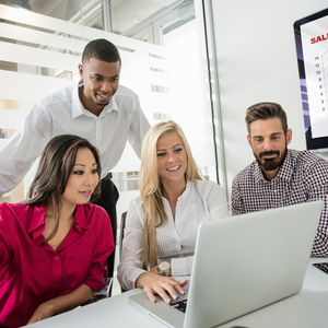 4 coworkers studying a checklist on a laptop
