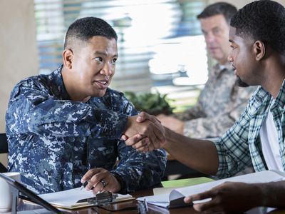 Military recruiter meeting with young man at military recruitment event