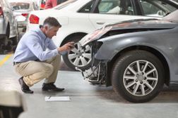 Insurance employee inspecting damage on a car