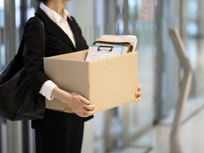 商人在被解雇后离开办公室带有个人物品盒。