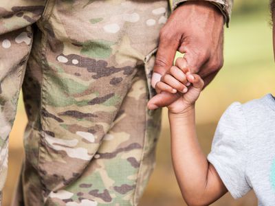 military dad holding daughter's hand