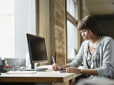 Female entrepreneur working at desk in creative office space