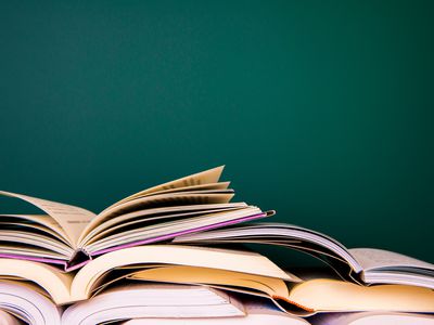 stack of open books against a wall