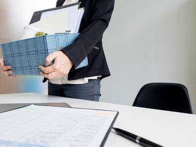 拿着盒子的女人在工作的最后一天离开办公室，因为她离开职业改变。