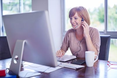 Woman at desk wearing a headset