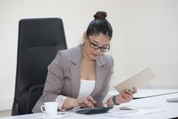 Businesswoman working with calculator at her office