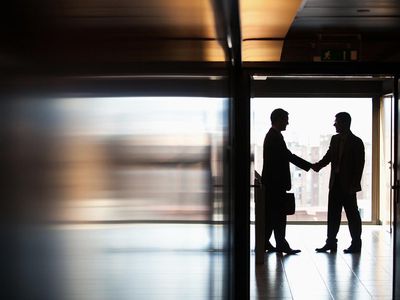Businessmen shaking hands in corridor