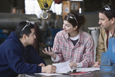 Three factory workers in informal meeting