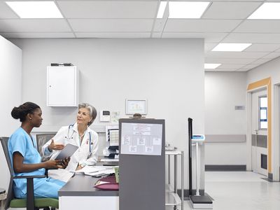 Elderly doctor gesturing while talking to coworker