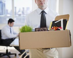 Man leaving office with belongings in a box