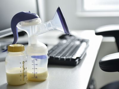 电脑旁有一个吸奶器和一瓶母乳