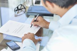 Businessman making notes at desk