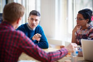 Two men and a woman talking in a meeting